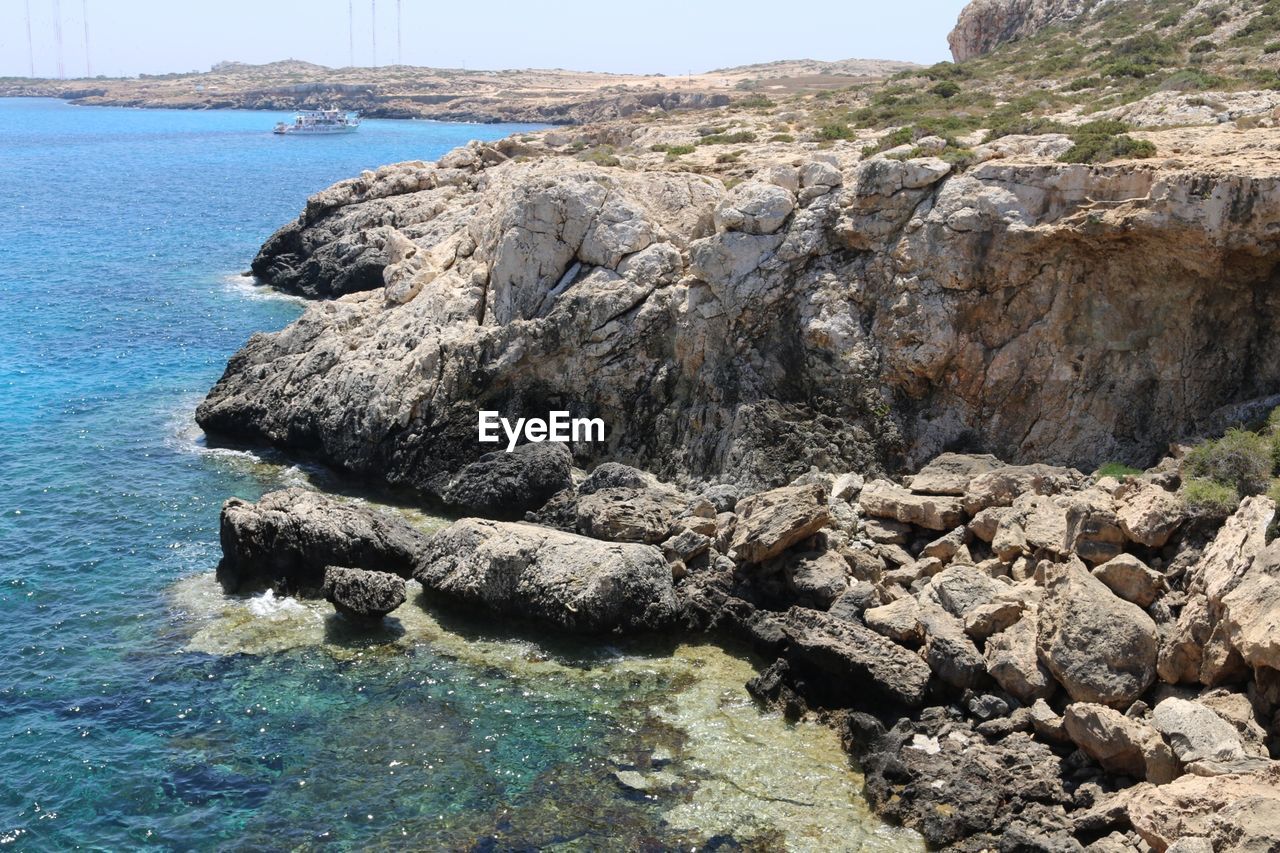 Rock formation by sea against sky