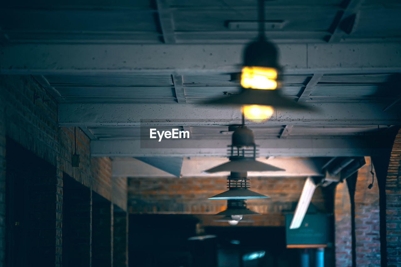 Low angle view of illuminated lights hanging on ceiling in building