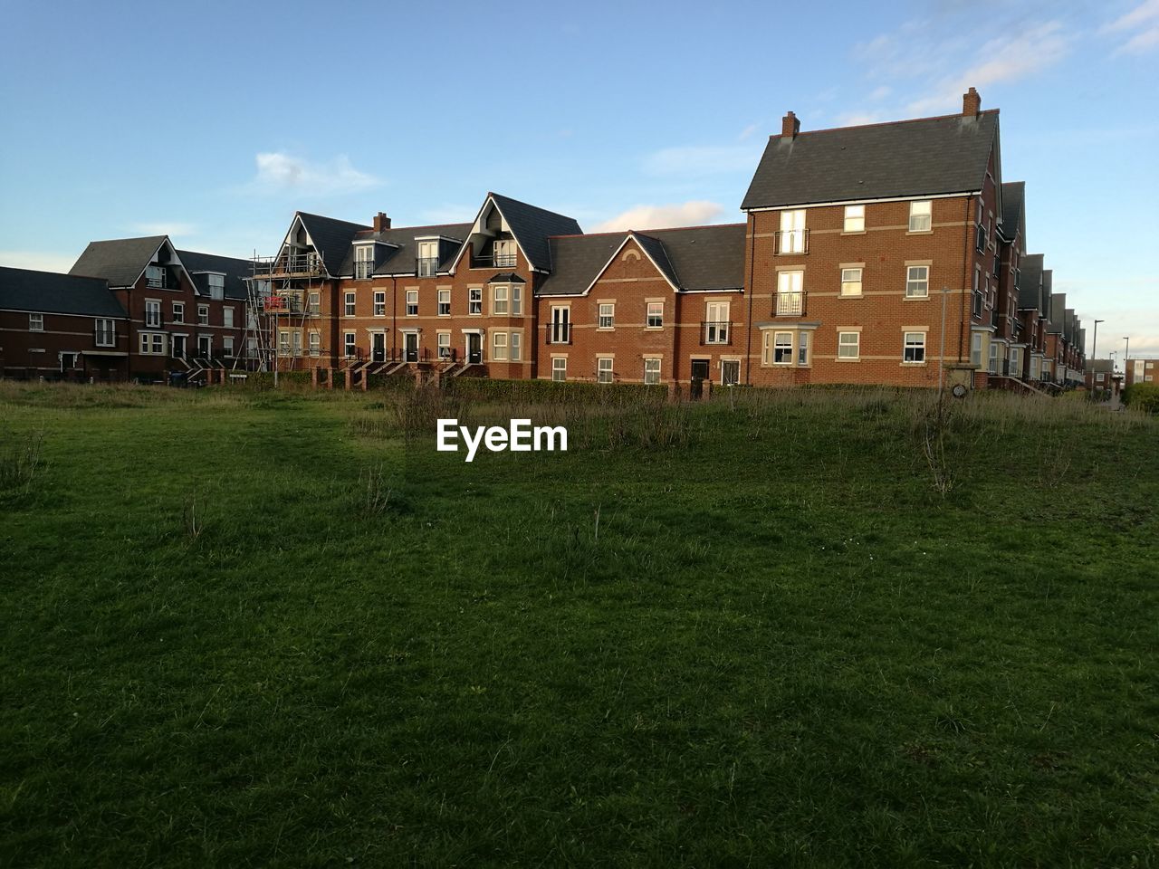 HOUSES ON FIELD AGAINST SKY