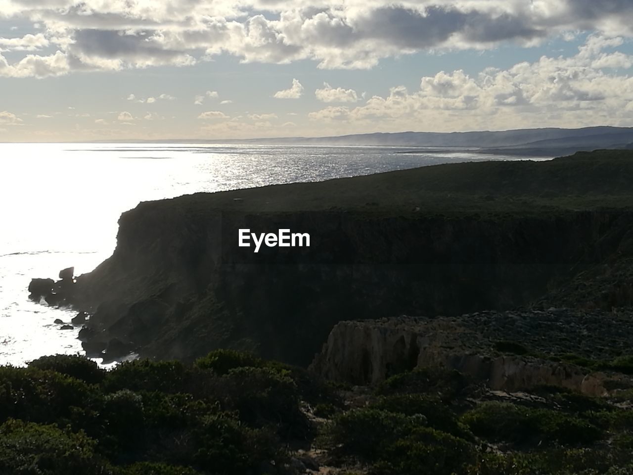 SCENIC VIEW OF SEA AND CLIFF AGAINST SKY