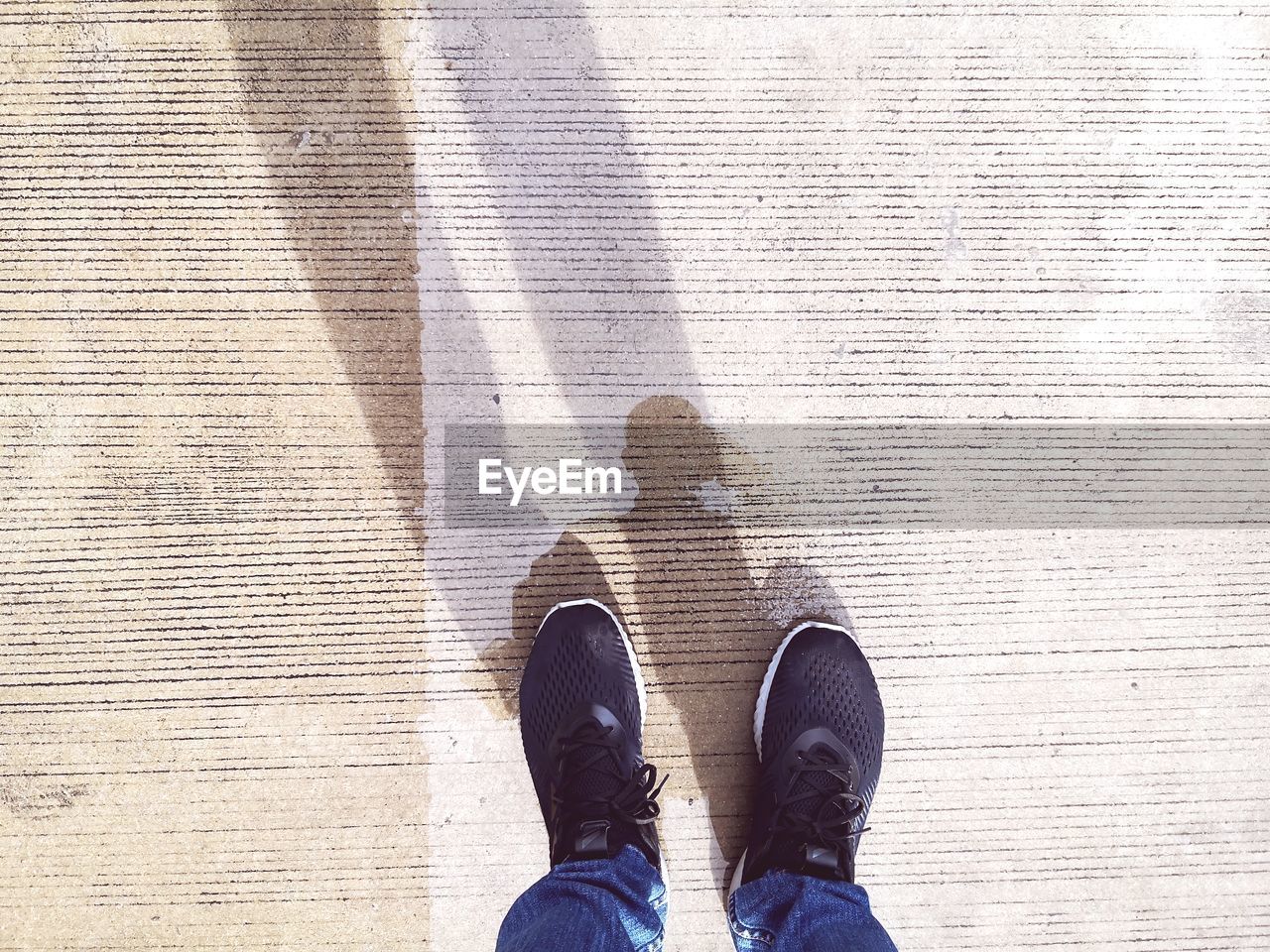 Low section of man standing on cement floor