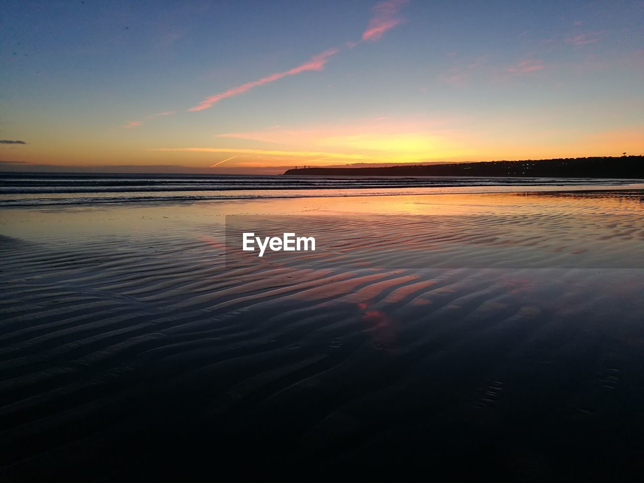 Scenic view of beach against sky during sunset