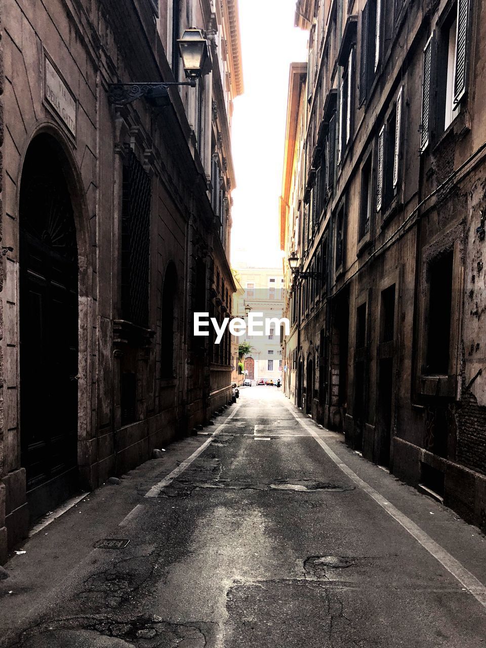 EMPTY ROAD AMIDST BUILDINGS