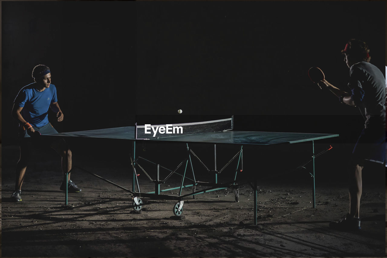 Male friends playing table tennis