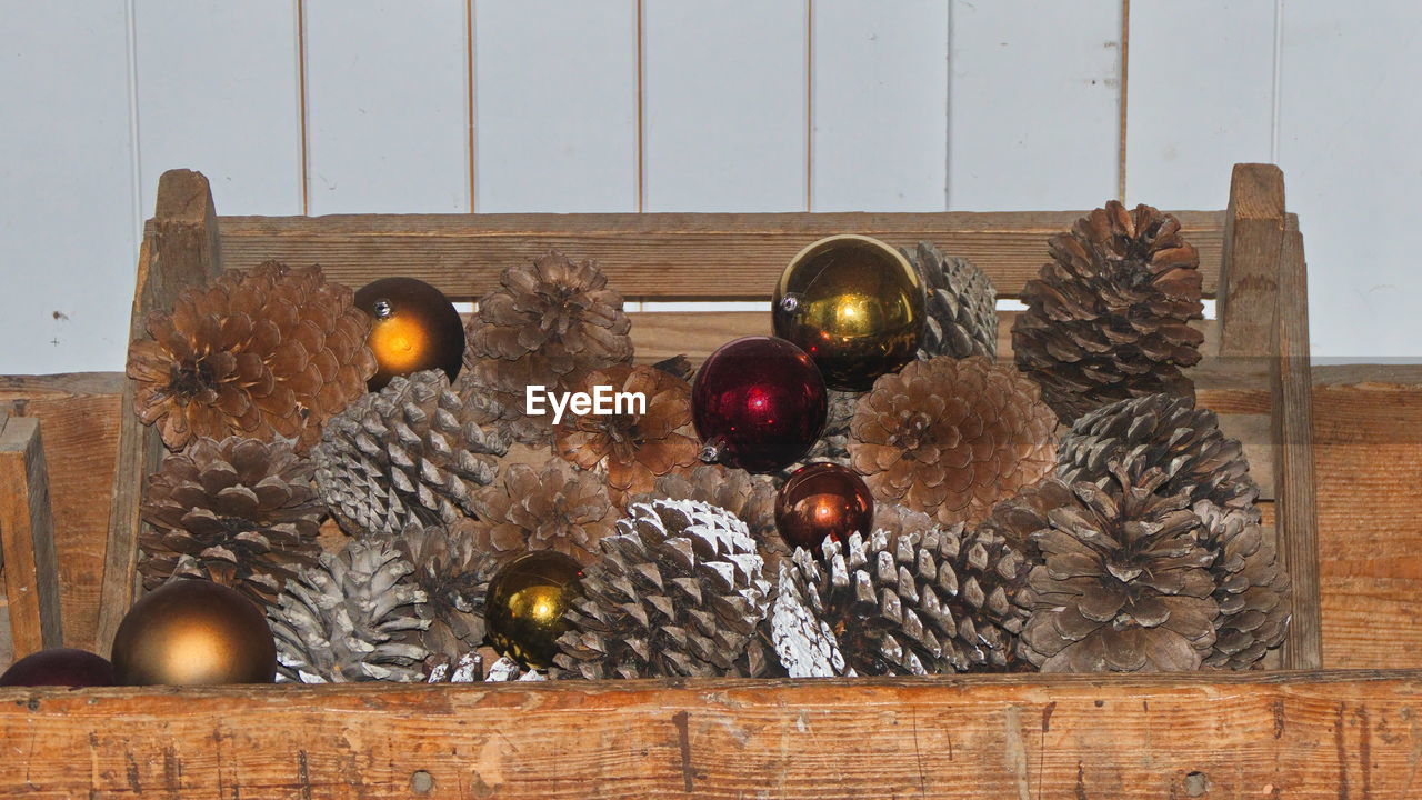 Close-up of christmas decoration with pine cone against wall