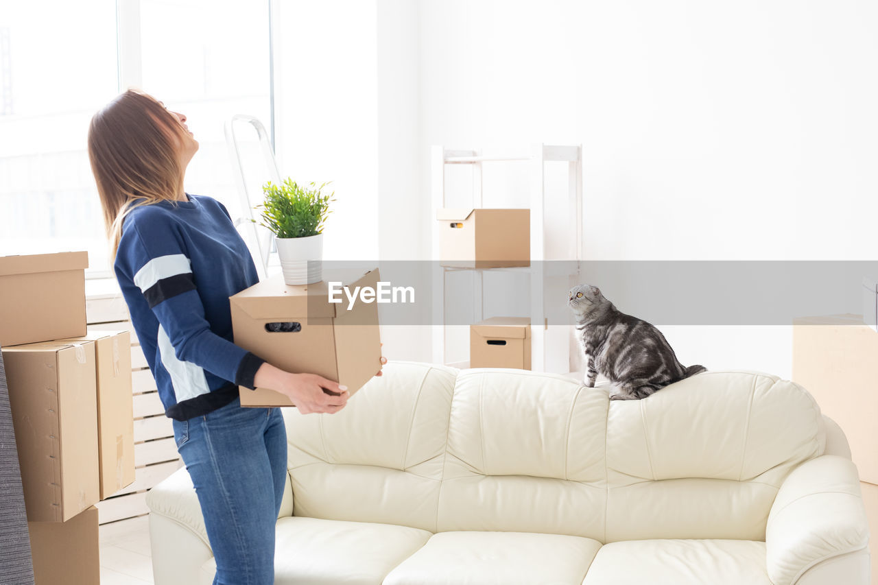 Woman carrying boxes at home