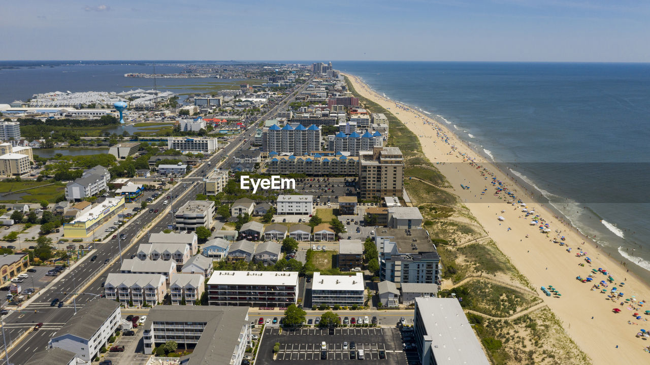 HIGH ANGLE VIEW OF BEACH AND BUILDINGS AGAINST SKY