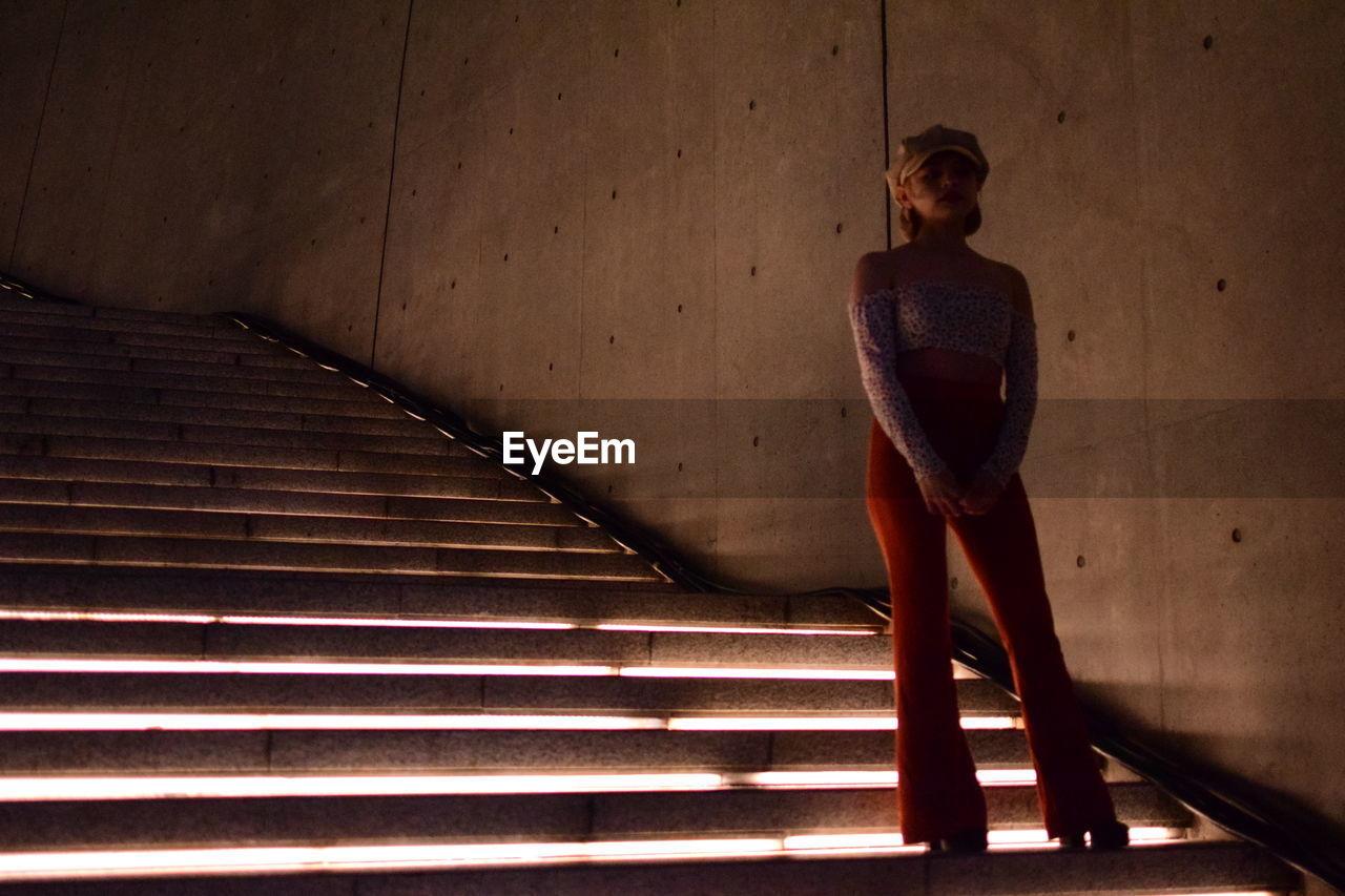 Low angle view of woman standing on staircase