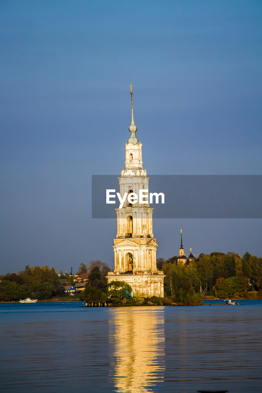 Beautiful christian church with golden domes among green trees.