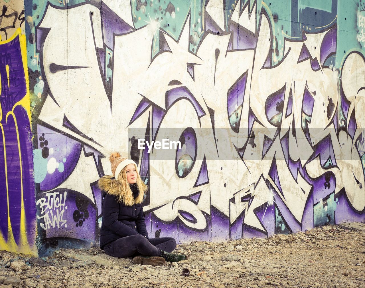 WOMAN SITTING WITH UMBRELLA IN BACKGROUND