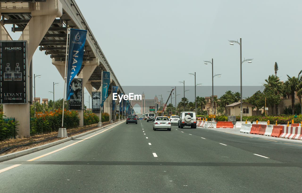 VEHICLES ON ROAD AGAINST SKY