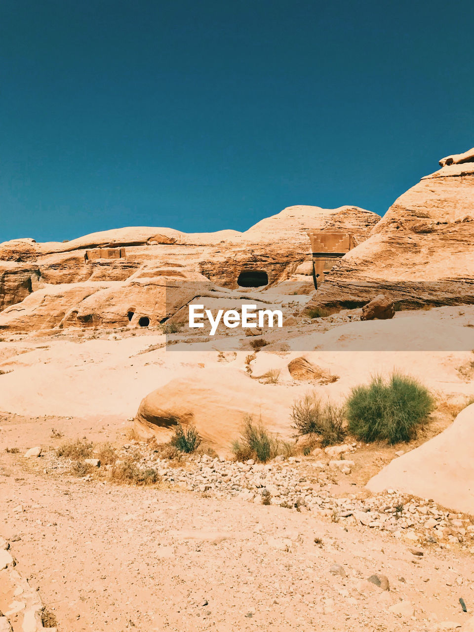 Scenic view of desert rocks against clear blue sky. petra