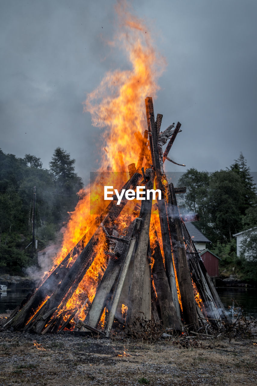 Bonfire on wooden structure against sky in summer
