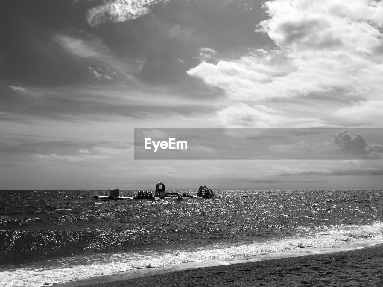 sky, sea, beach, water, land, cloud, horizon, black and white, nature, horizon over water, sand, wave, scenics - nature, beauty in nature, monochrome photography, ocean, shore, monochrome, coast, body of water, holiday, tranquility, travel destinations, trip, environment, vacation, travel, wind wave, group of people, tranquil scene, outdoors, motion, animal, day, white, sunlight, summer, leisure activity, animal themes, tourism, mammal, coastline, non-urban scene