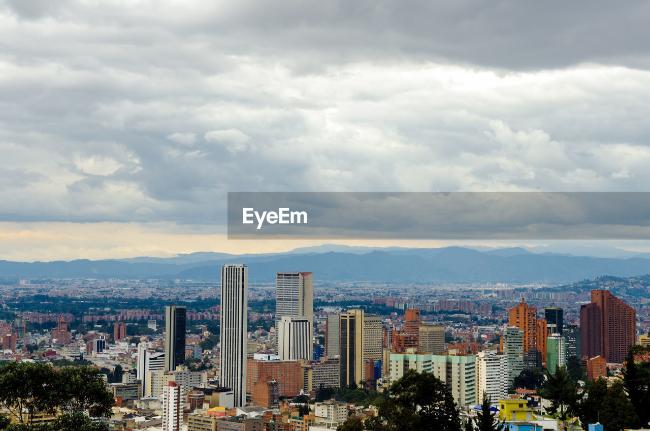 View of cityscape against cloudy sky