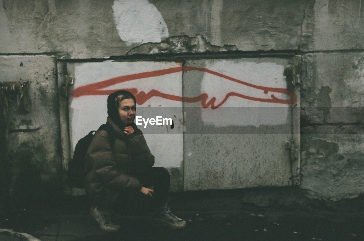 YOUNG MAN LOOKING THROUGH WALL