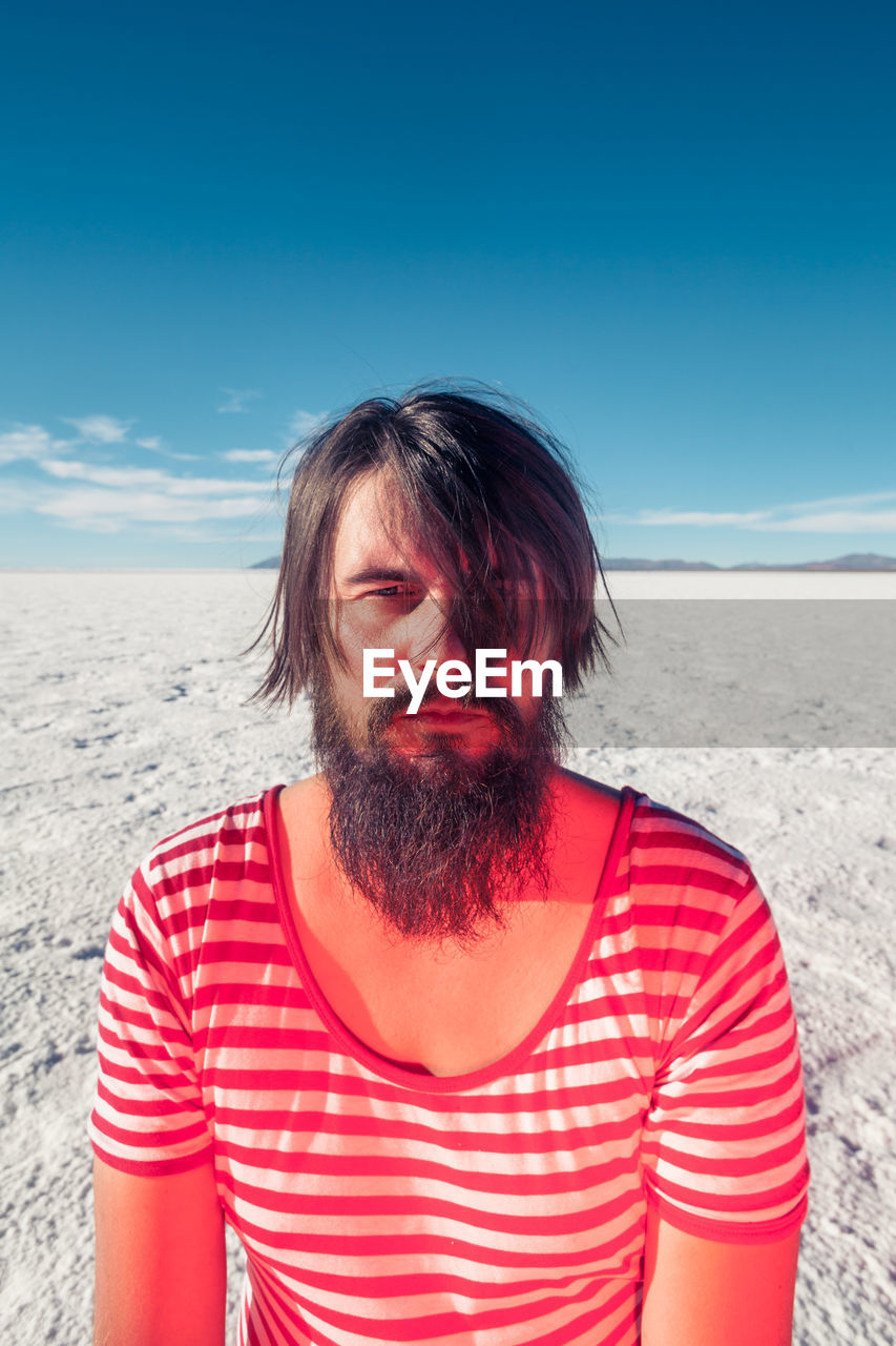 Mid adult man at beach against sky