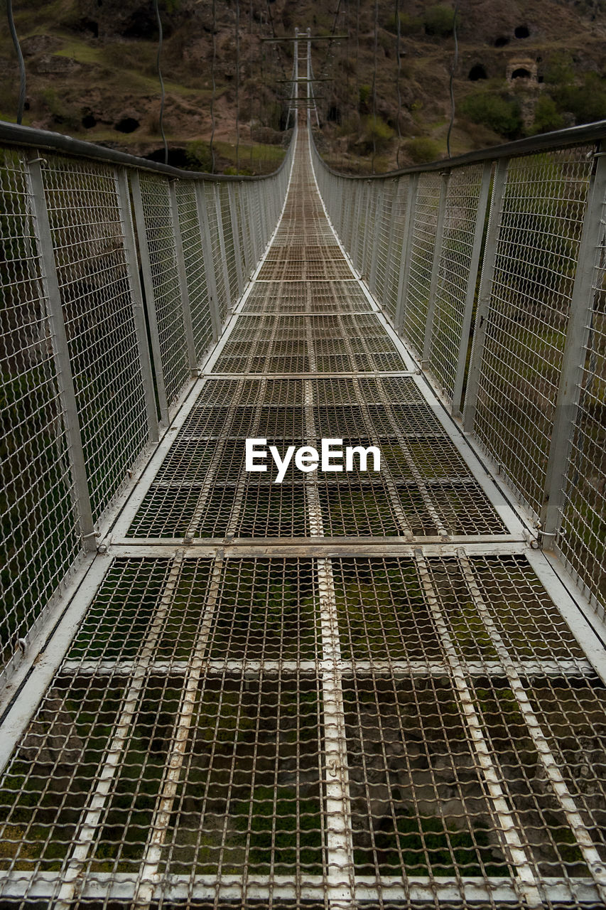 HIGH ANGLE VIEW OF FOOTBRIDGE OVER EMPTY ROAD