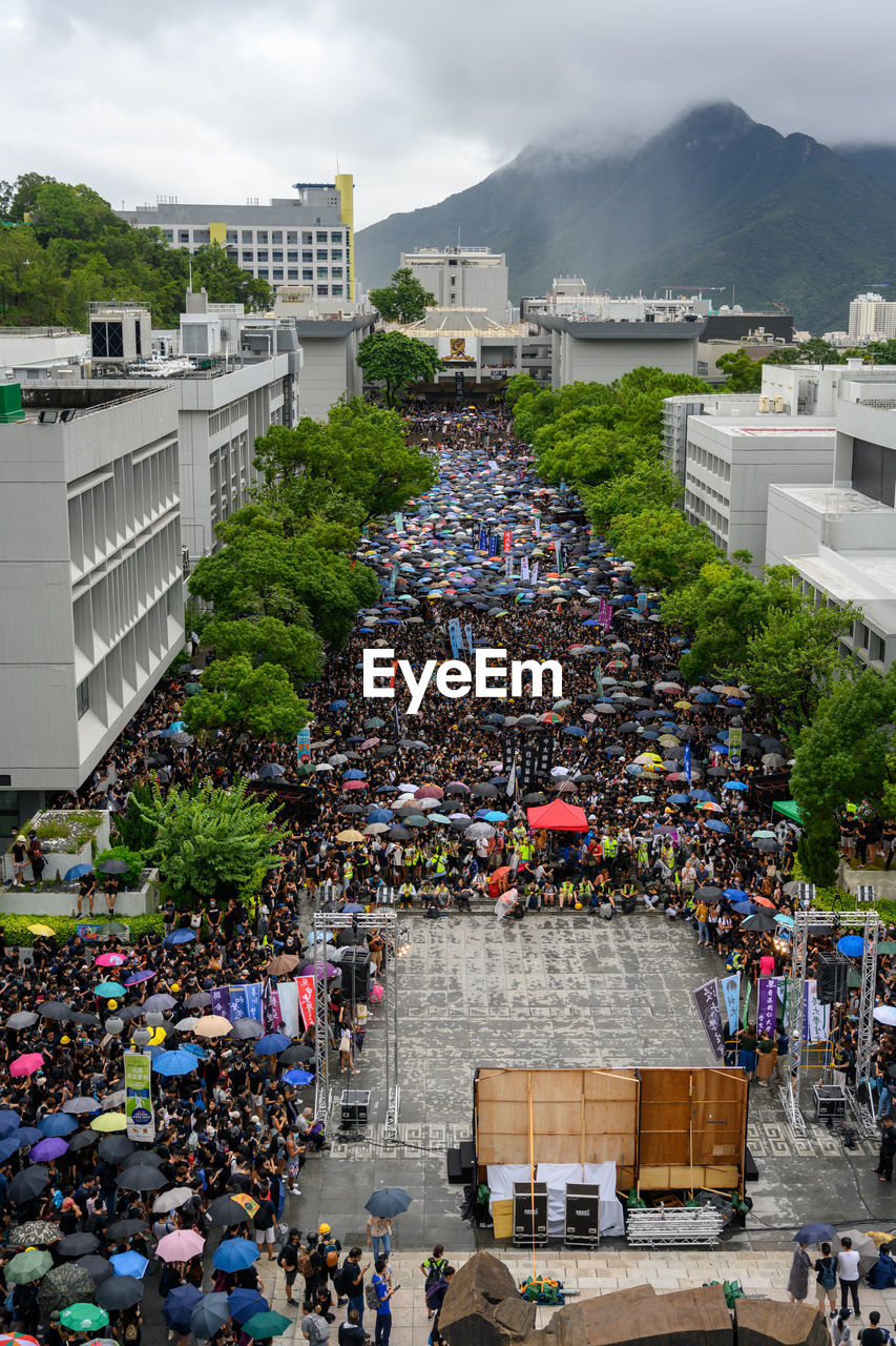 HIGH ANGLE VIEW OF PEOPLE ON STREET AMIDST BUILDINGS