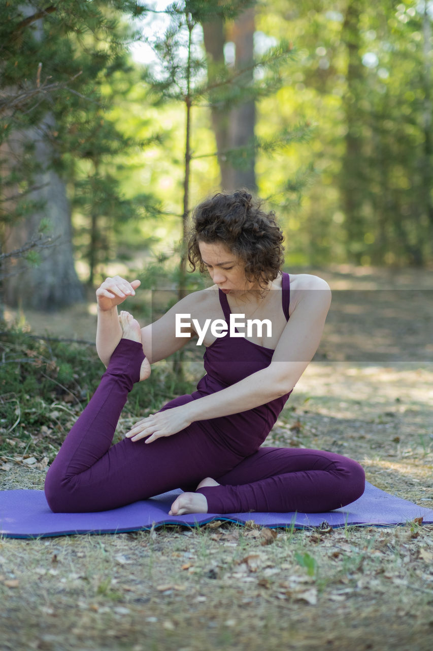 side view of young woman exercising on field