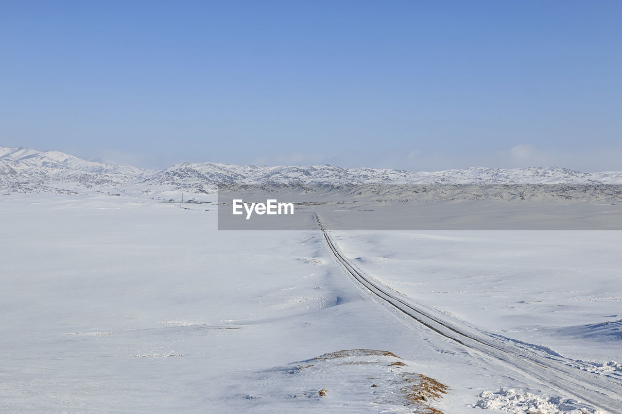 Snow covered landscape against clear sky