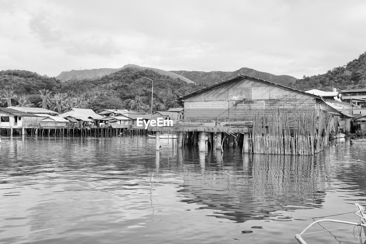 HOUSES BY LAKE AGAINST SKY