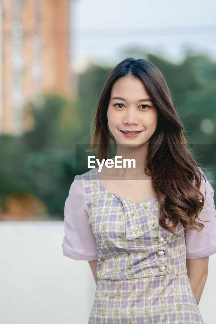 Portrait of a smiling young woman standing outdoors