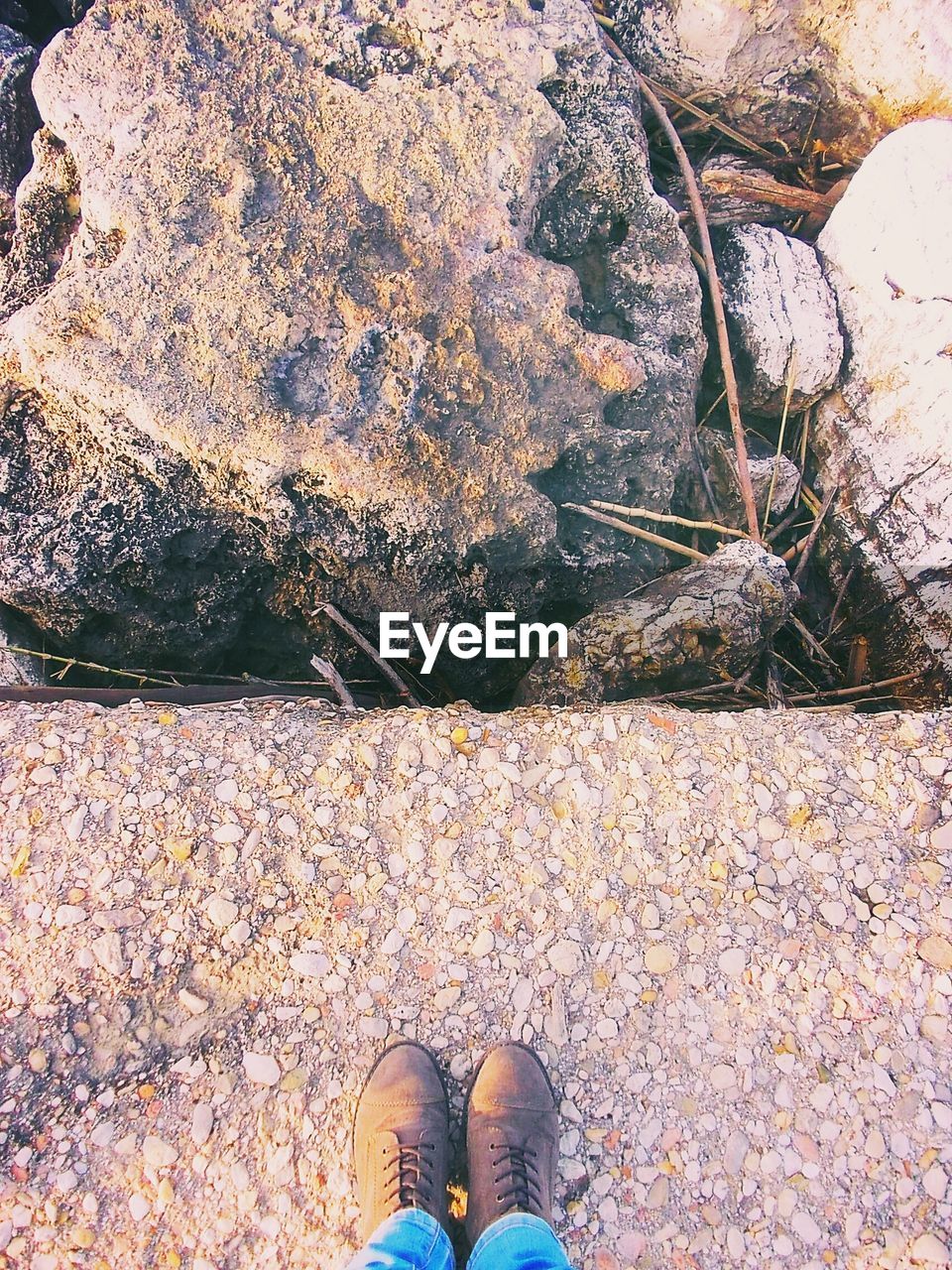 Low section of person standing on stone pier