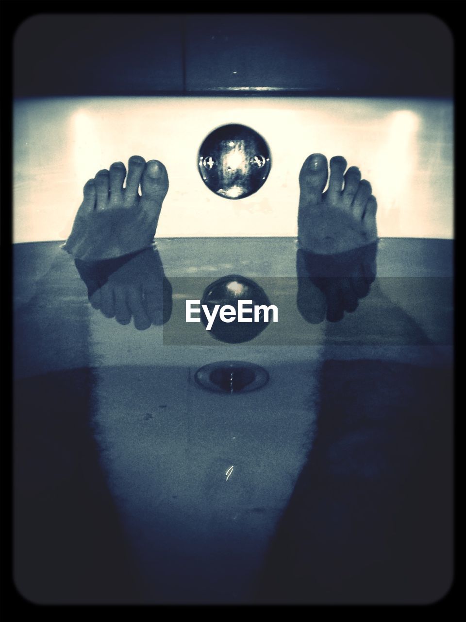 Low section of man relaxing in bathtub