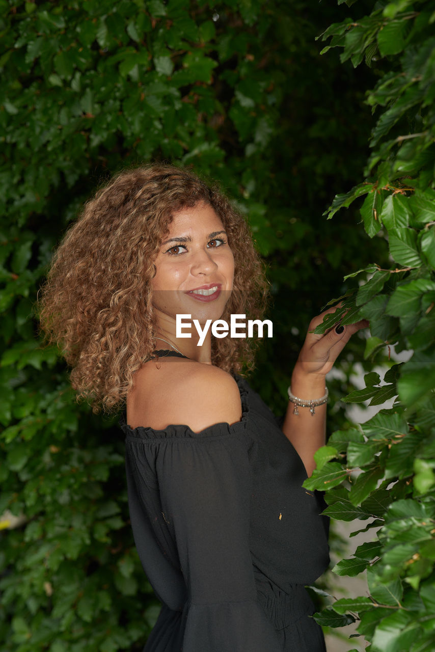 Portrait of smiling woman by plants