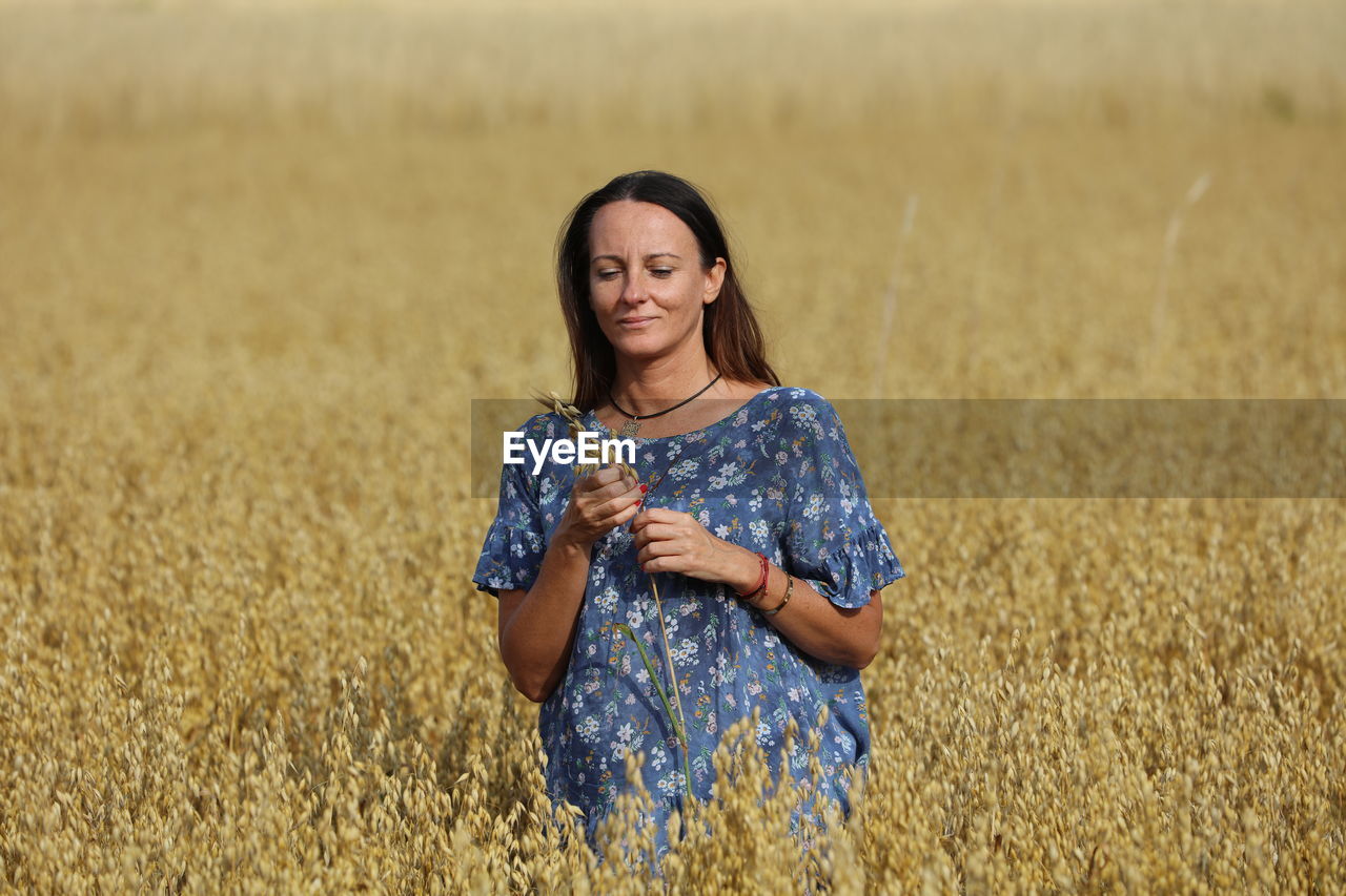 Portrait of a smiling young woman standing in field