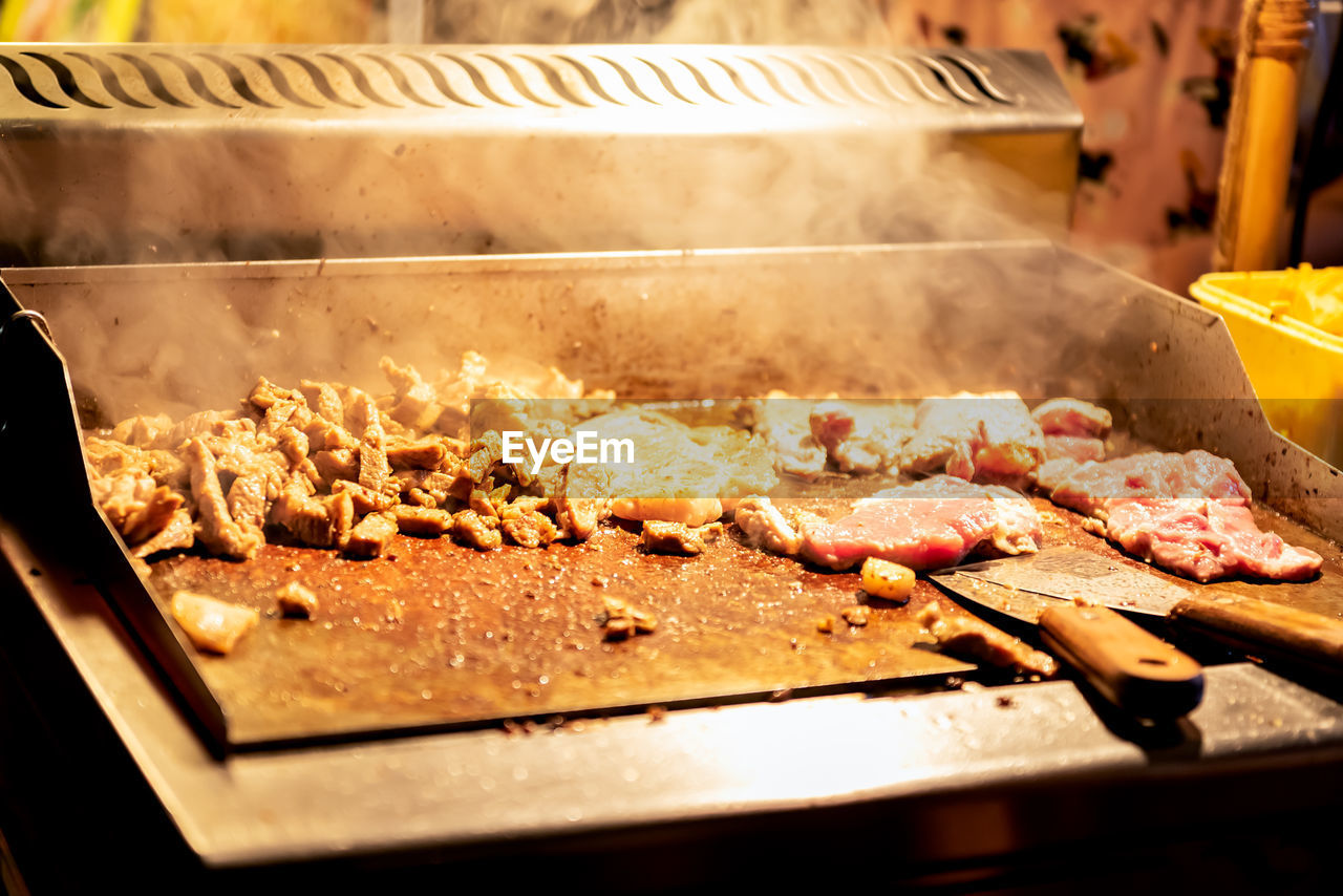 CLOSE-UP OF MEAT ON CUTTING BOARD IN KITCHEN