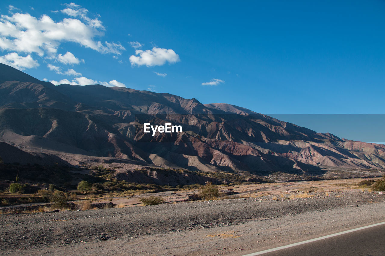 SCENIC VIEW OF ROAD BY MOUNTAINS AGAINST SKY