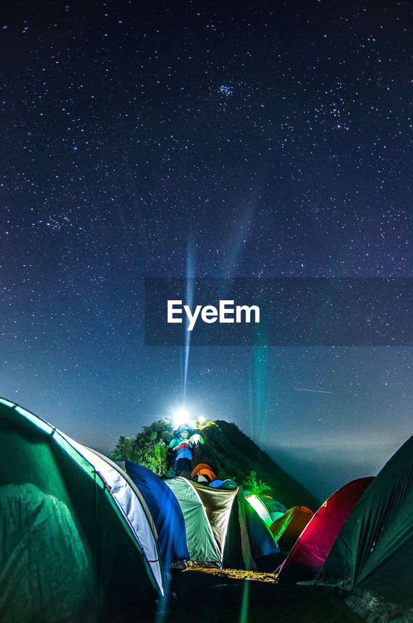 Illuminated tents against star field at night
