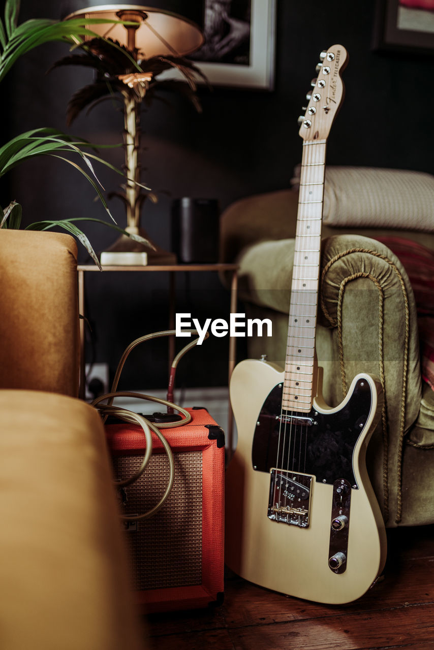 CLOSE-UP OF GUITAR IN SOFA