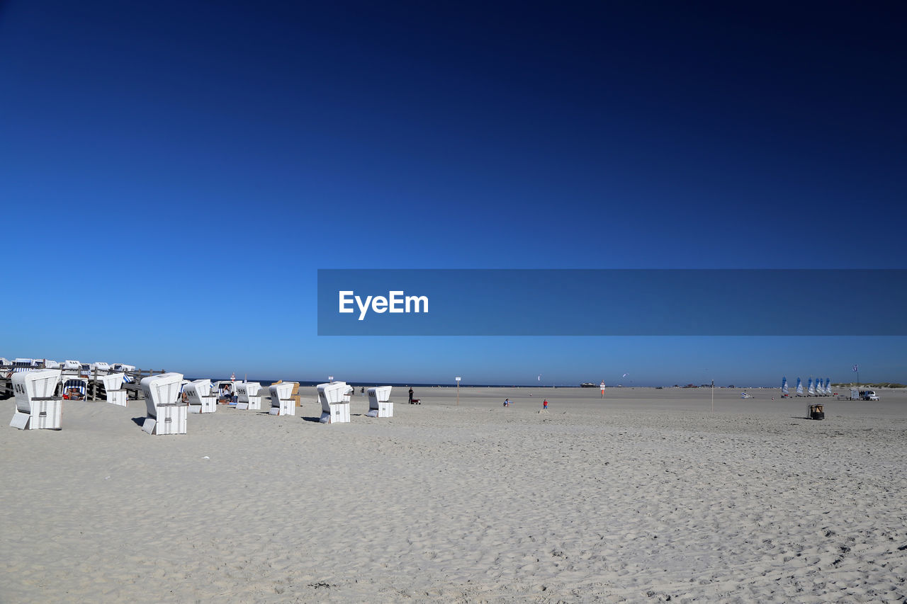 Scenic view of beach against clear blue sky