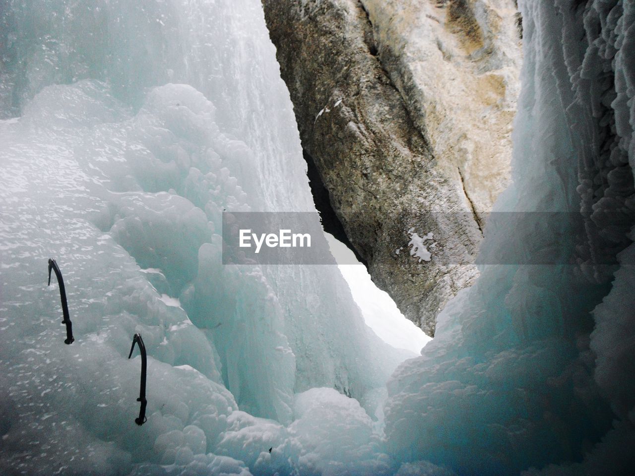 Low angle view of axes on ice formation