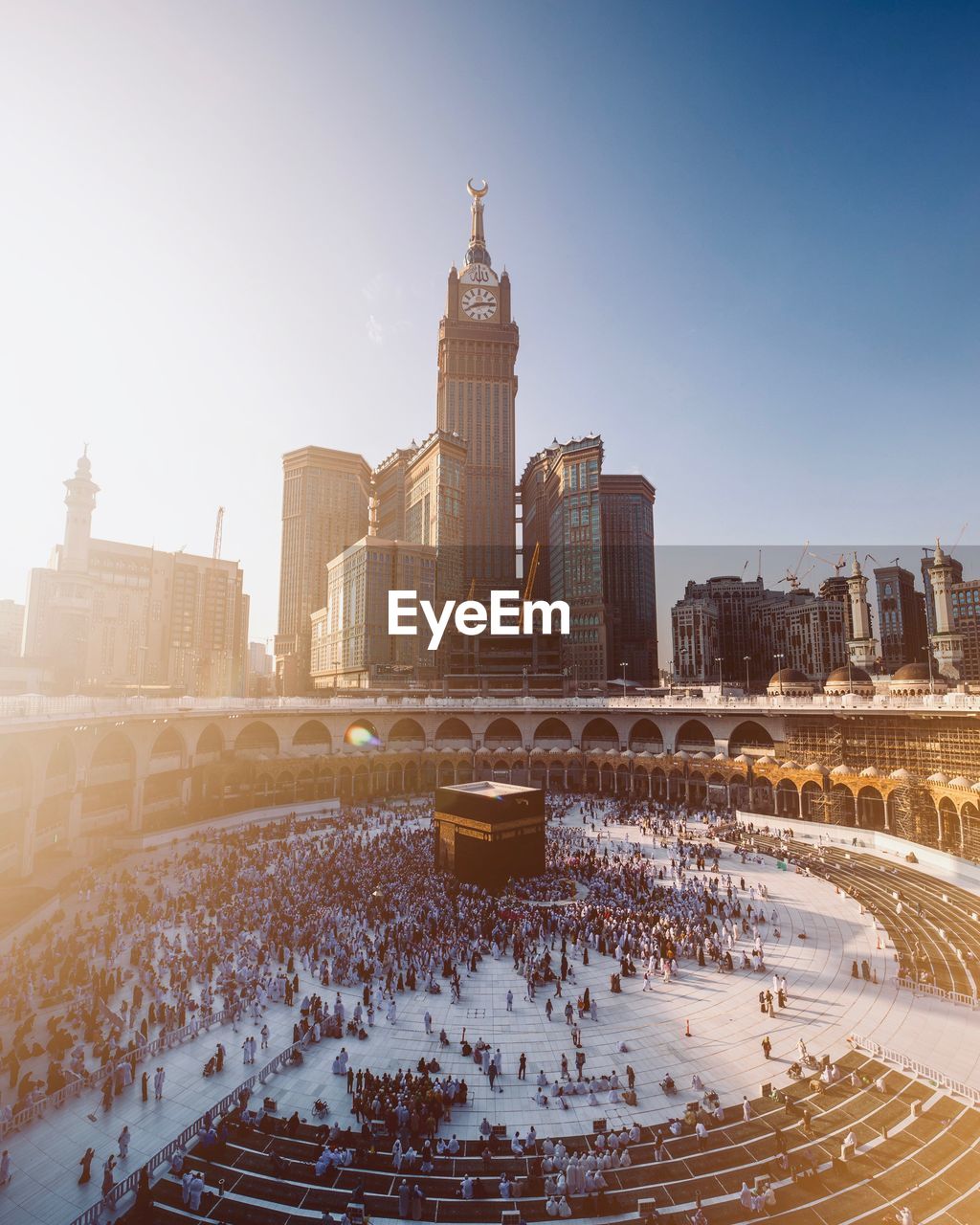 High angle view of people in mecca by modern buildings against clear sky