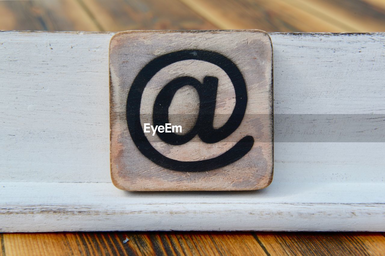 High angle view of at symbol on wooden table