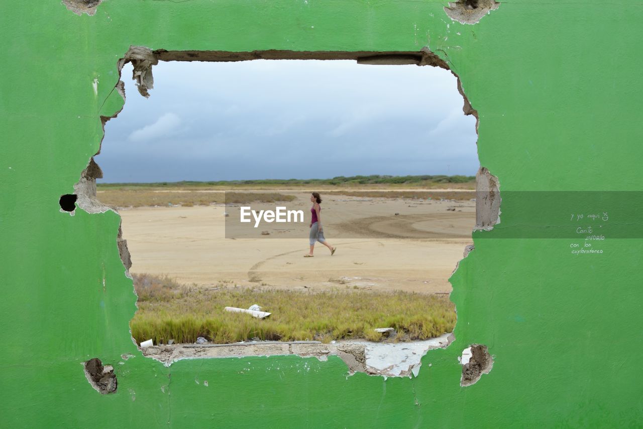 WOMAN STANDING ON BEACH