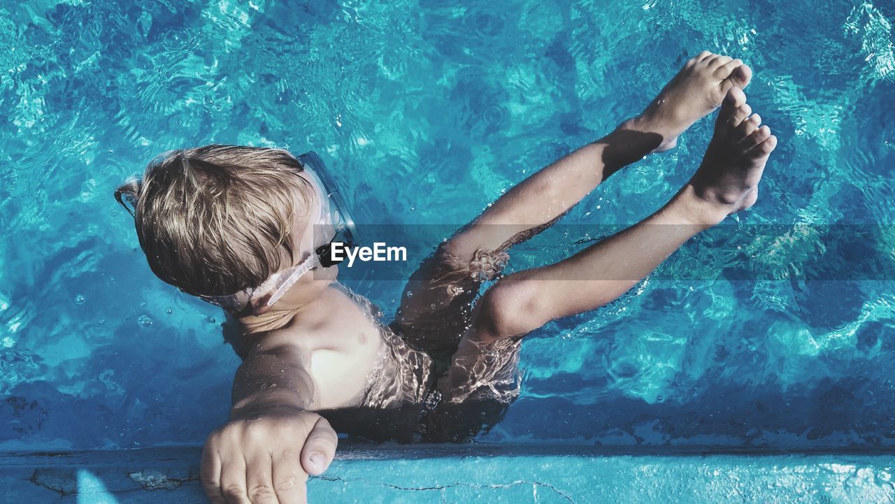 Full length of shirtless boy swimming in pool