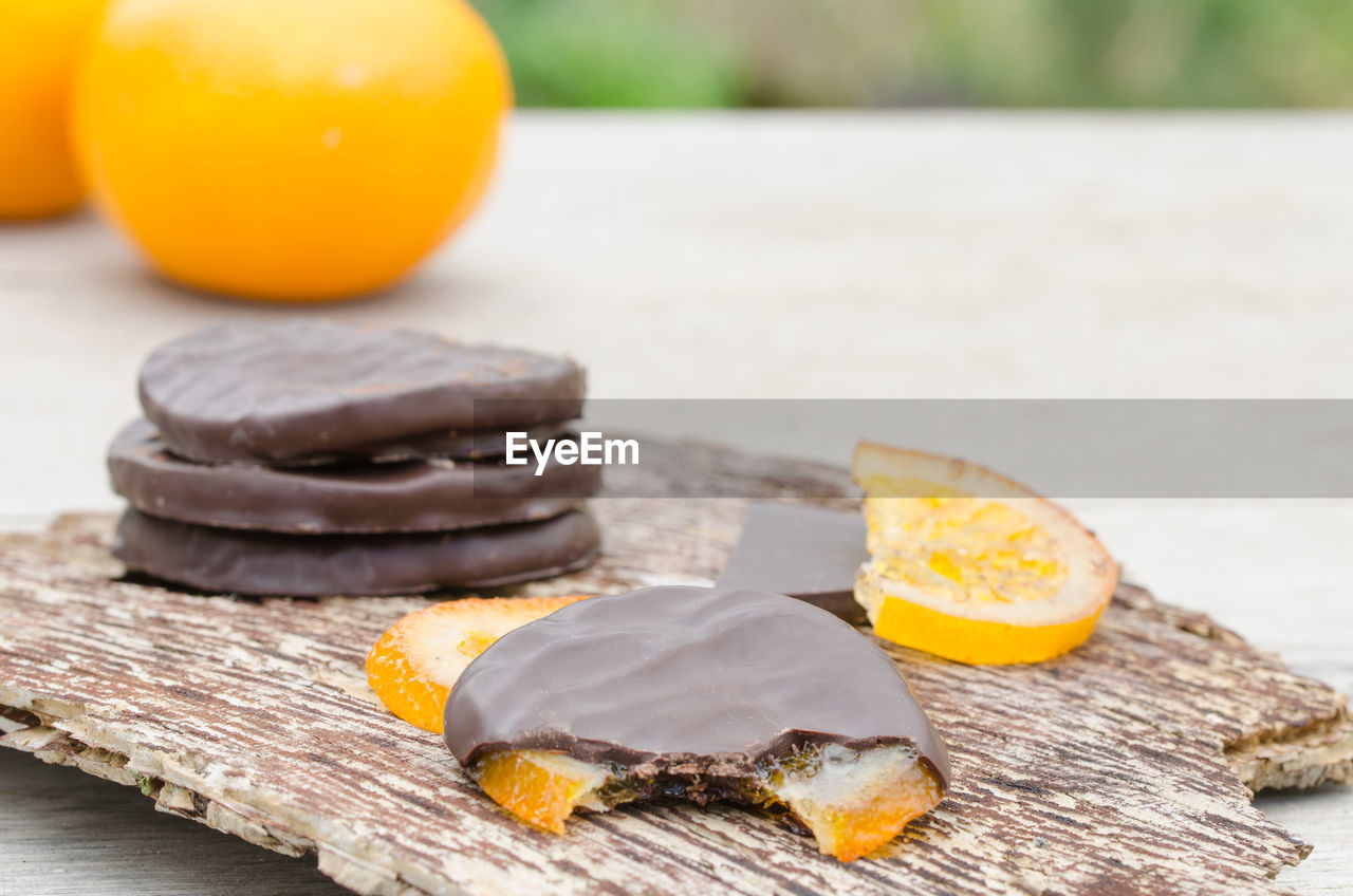 Close-up of chocolates with oranges on table