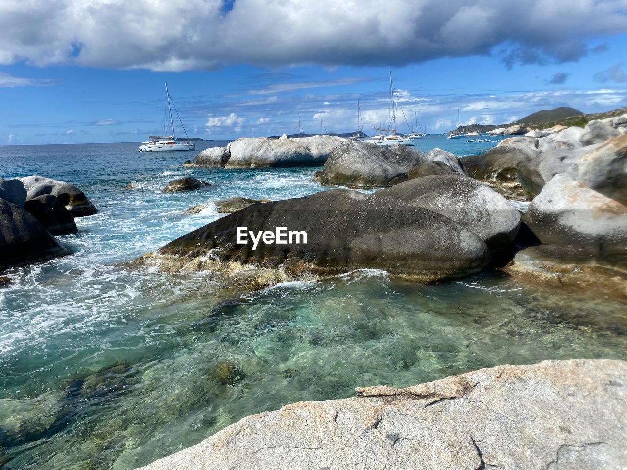 SCENIC VIEW OF ROCKS ON BEACH AGAINST SKY