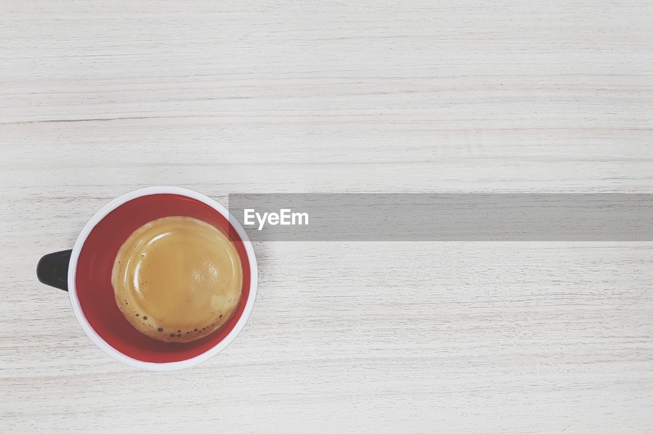 HIGH ANGLE VIEW OF COFFEE CUP WITH TEXT ON TABLE