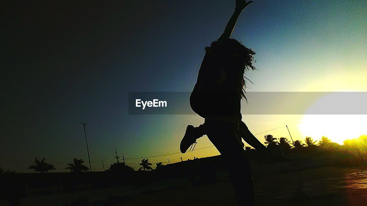 LOW ANGLE VIEW OF SILHOUETTE WOMAN AGAINST CLEAR SKY