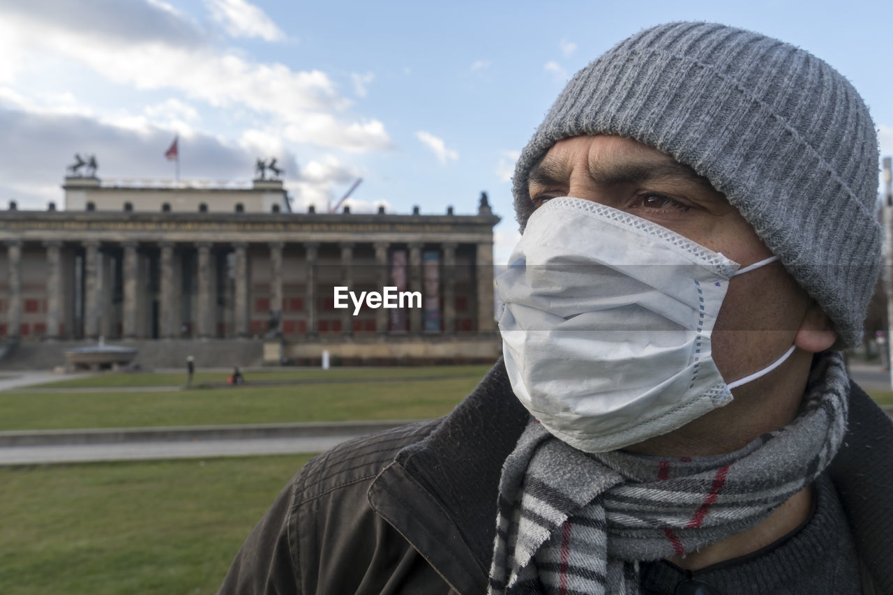 Tourism during coronavirus. man with medical mask to protect nose and mouth in front of altes museum