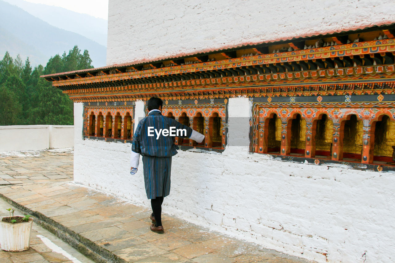 FULL LENGTH REAR VIEW OF A MAN WALKING IN A BUILDING