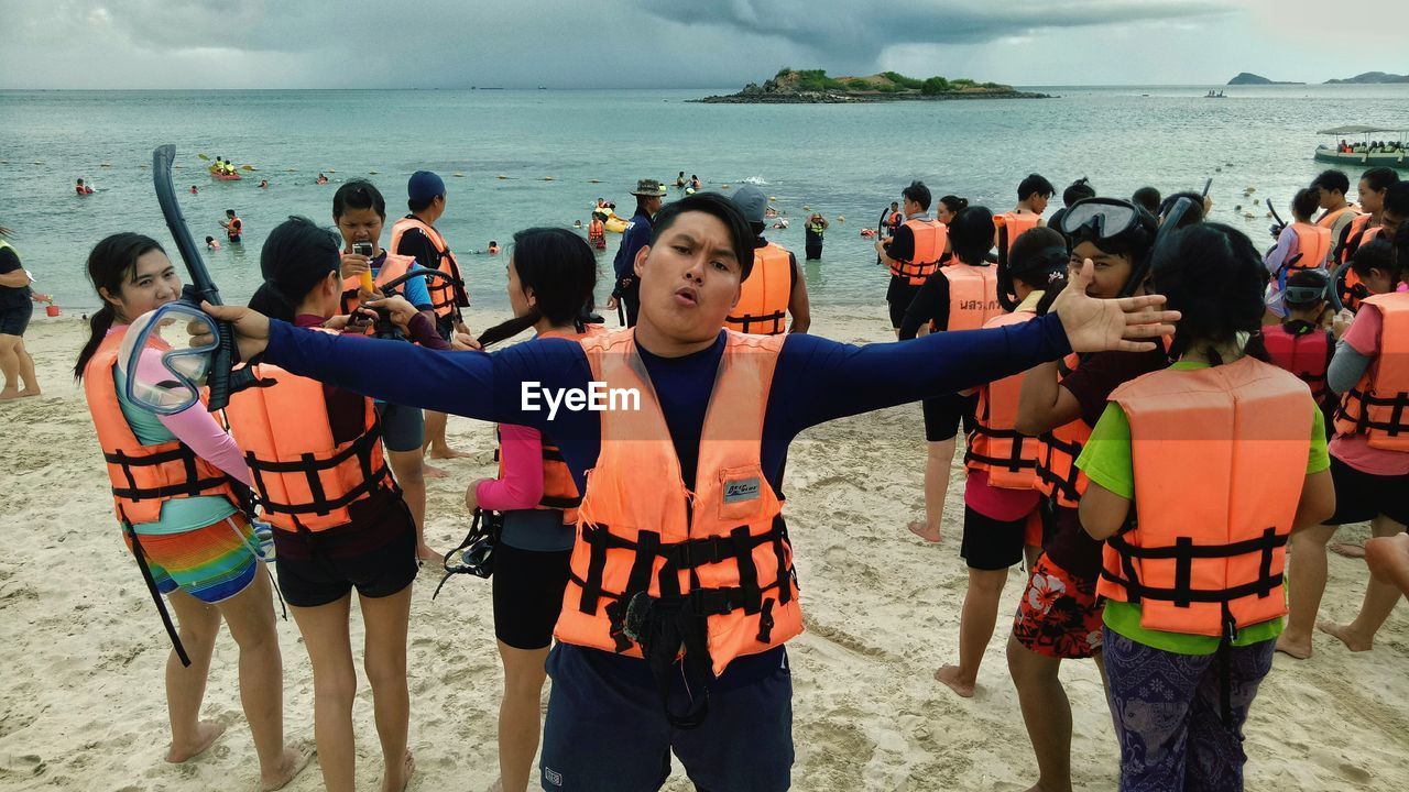 FRIENDS STANDING ON BEACH