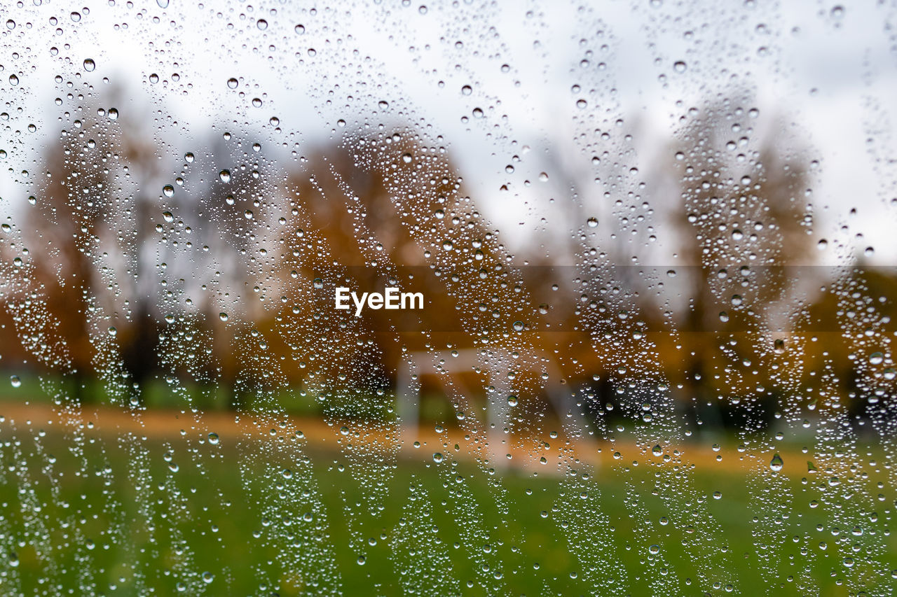 FULL FRAME SHOT OF RAINDROPS ON GLASS WINDOW