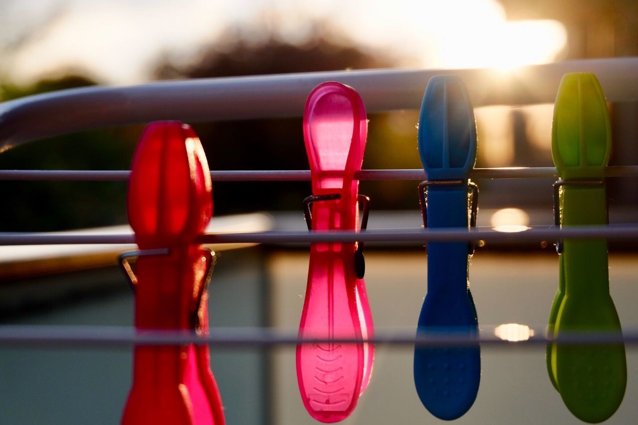 Close-up of multi colored clothespins hanging on cables